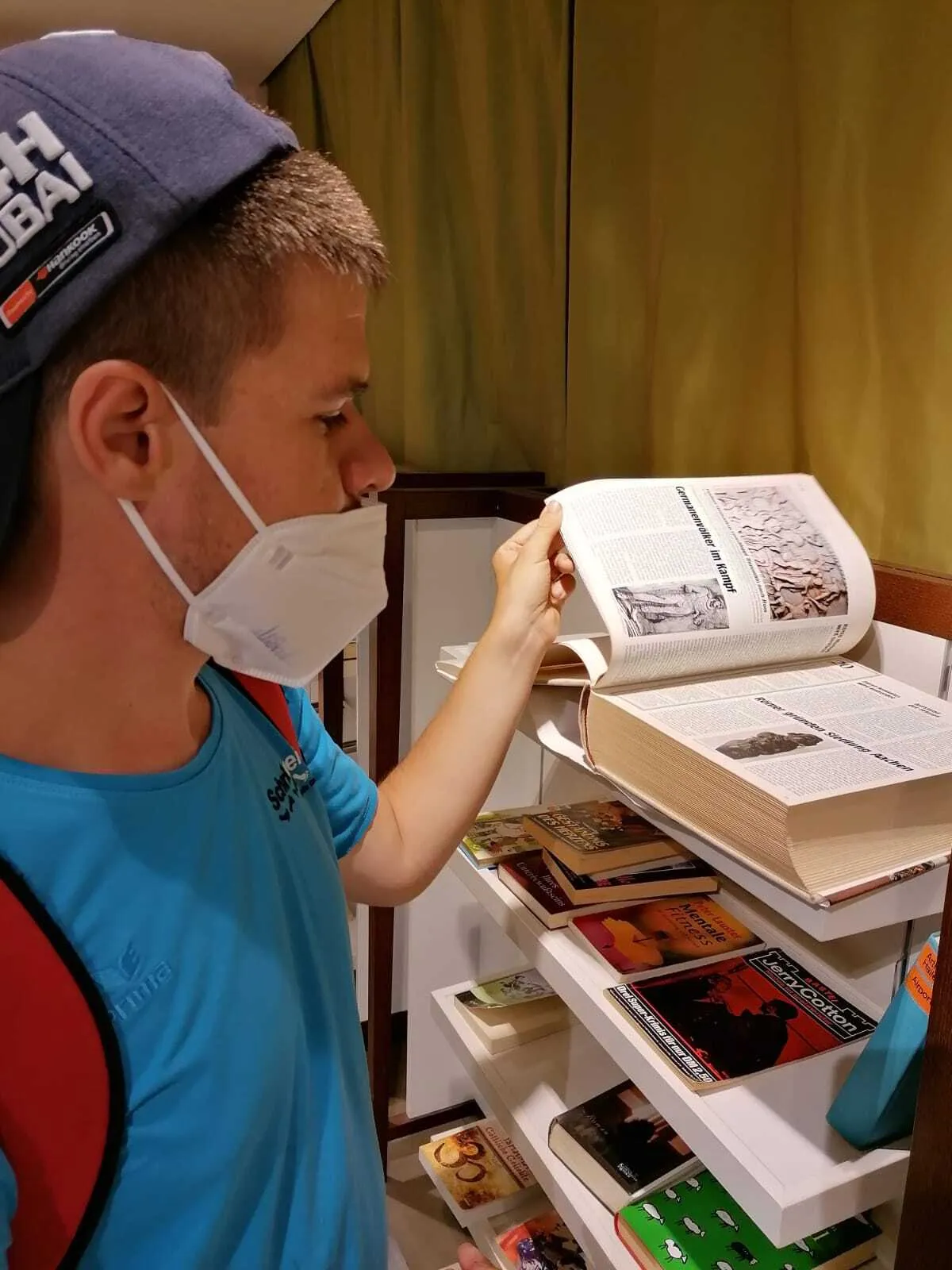 Mann mit Maske liest in einem Buch