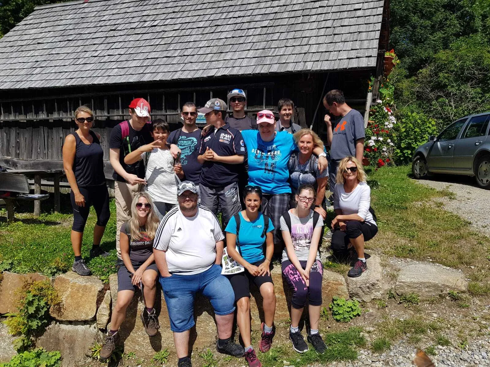 Gruppe steht bei einem gemeinsamen Ausflug vor einer Hütte